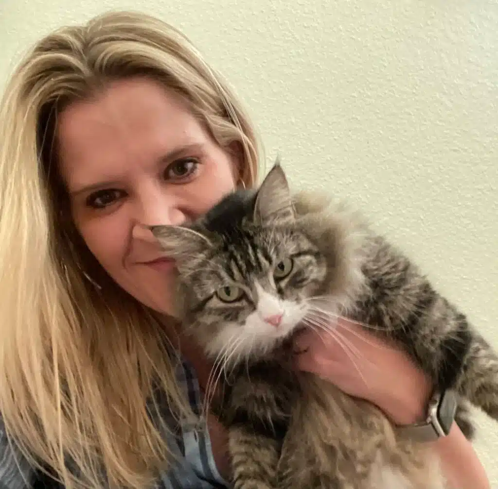 Monica Tarant, co-founder of Cabin Companions, holding a cat and smiling.