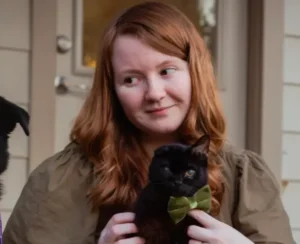 Natascha - a vet tech and Cabin Companion holds a black cat.